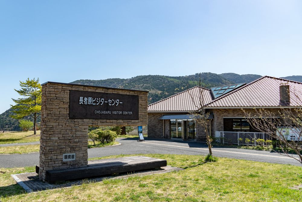 a building surrounded by blue skies and green grassland