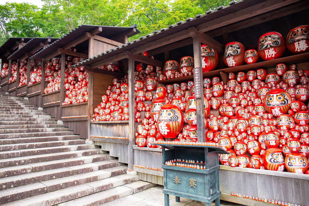 Numerous Daruma dolls lined up on the steps of Katsuo-ji Temple