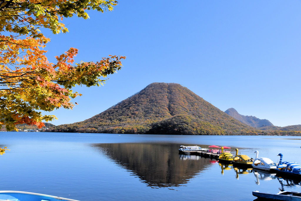 Lake Haruna with autumn leaves and boats in the foreground