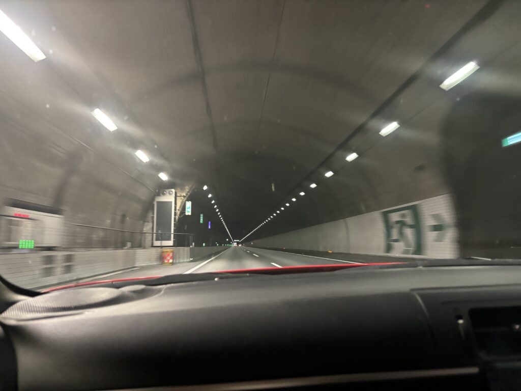 View from inside a car driving through a well-lit tunnel