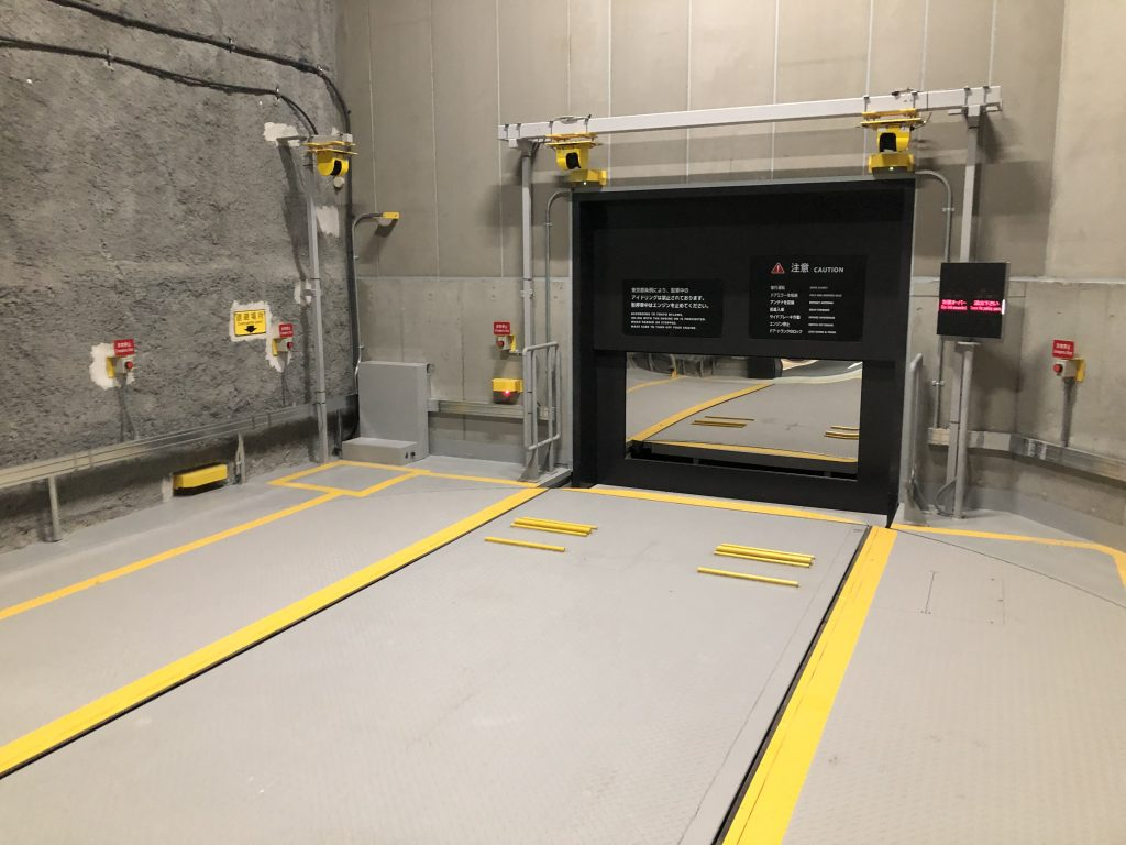 automated parking system platform with yellow safety markers and warning signs