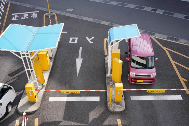 Parking lot ticket gate with overhead canopy and waiting vehicle