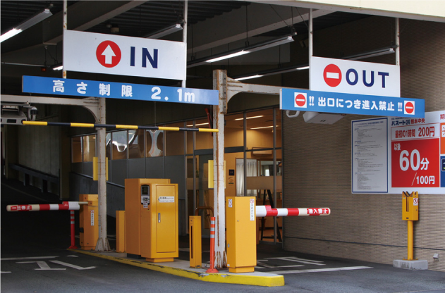 Parking garage entrance with IN OUT signs and height restrictions