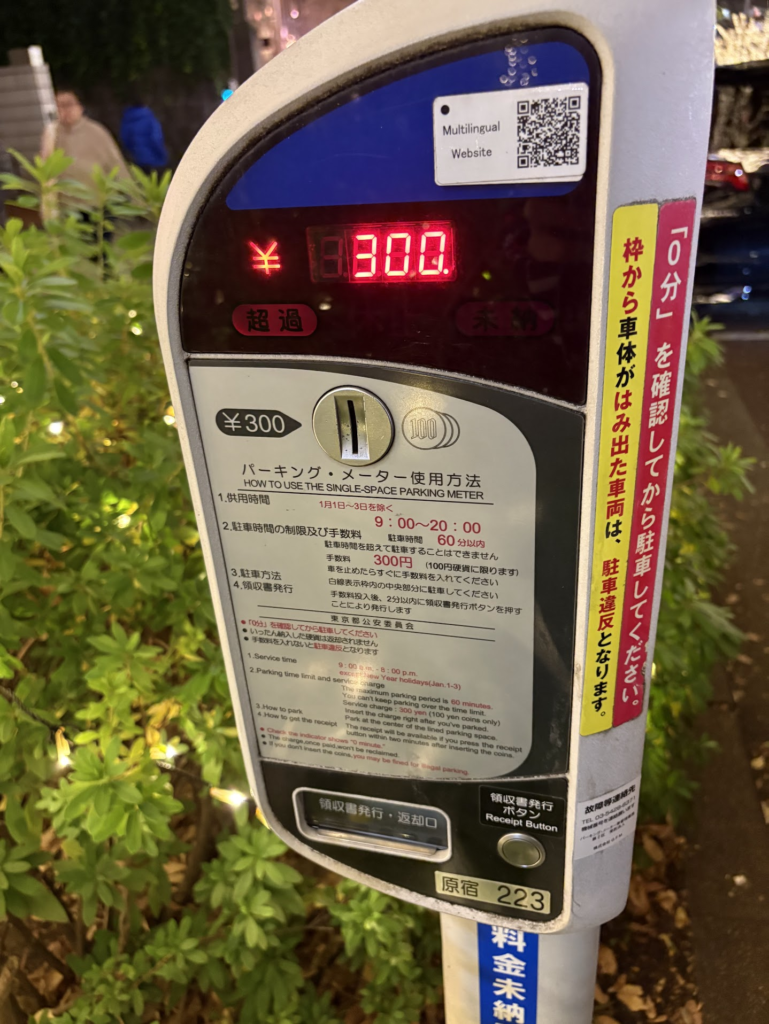 Digital parking meter showing 300 yen fee with multilingual instructions