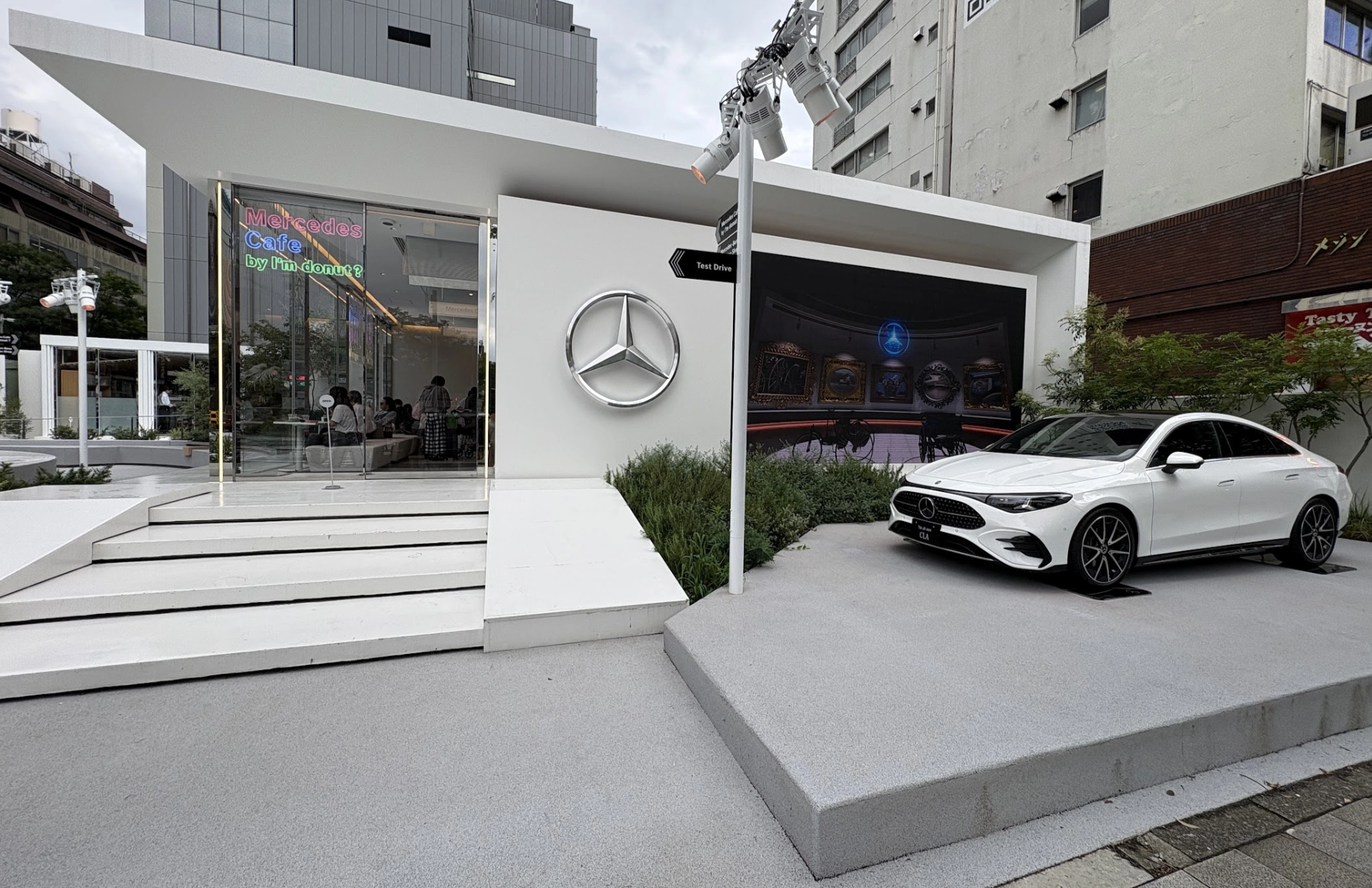 Mercedes-Benz Studio Tokyo exterior with new CLA sedan on display and Mercedes Cafe entrance