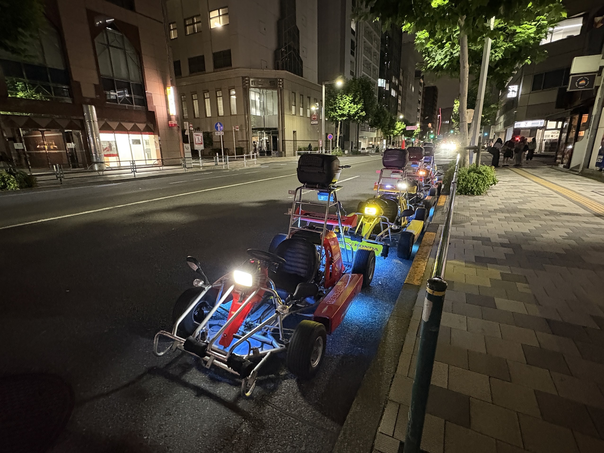 Shibuya go kart tour vehicles lined up on Tokyo street at night