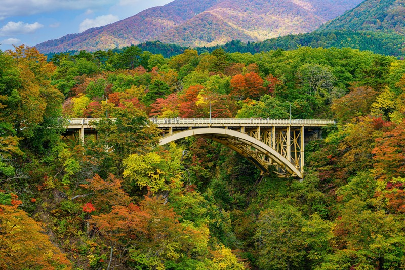 Ofukazawa Bridge surrounded by autumn foliage at Naruko Gorge