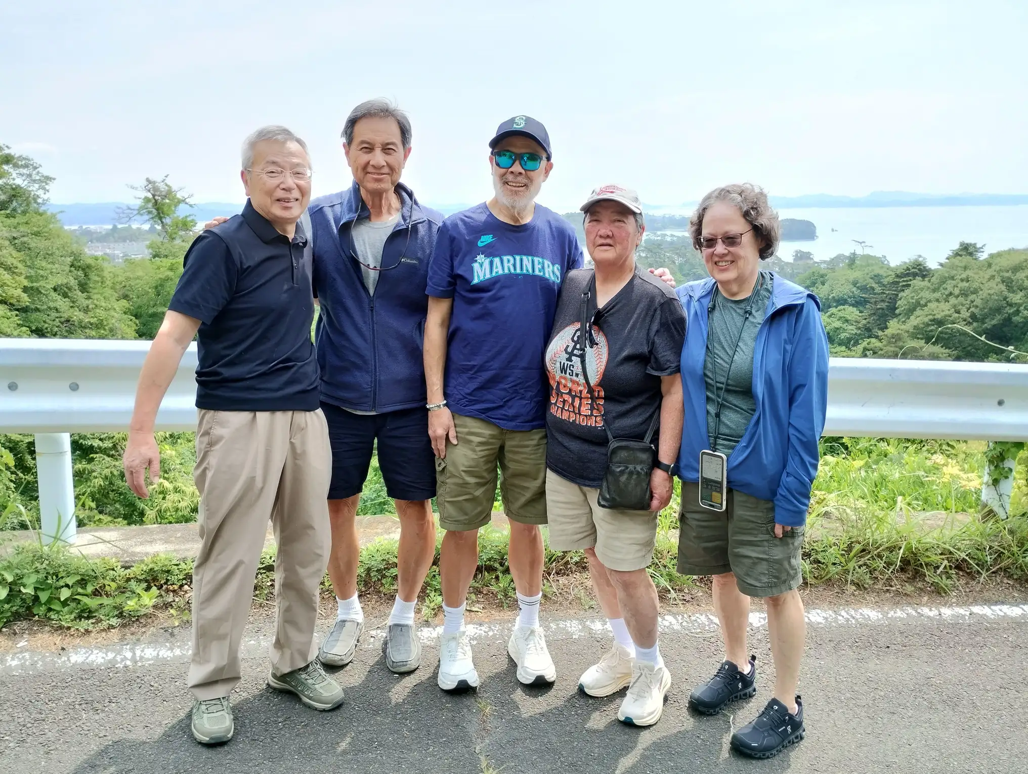 Five people posing at a scenic overlook above Matsushima Bay